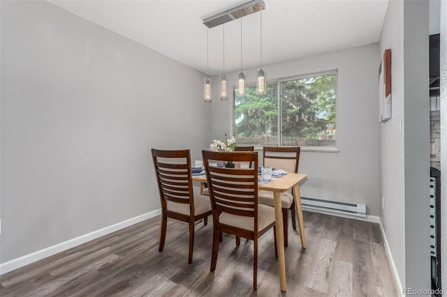 dining space featuring dark hardwood / wood-style flooring and a baseboard heating unit