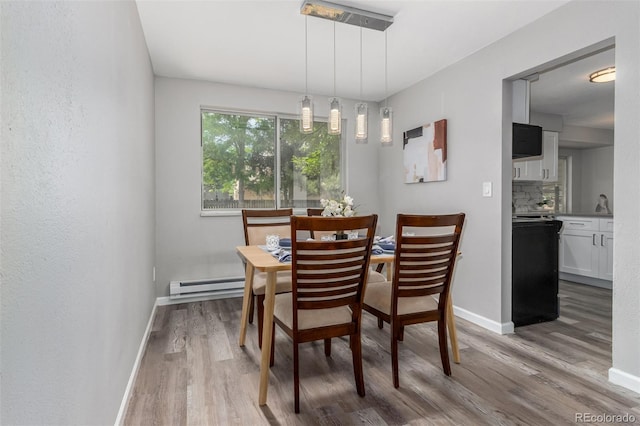 dining room with light wood-type flooring and baseboard heating