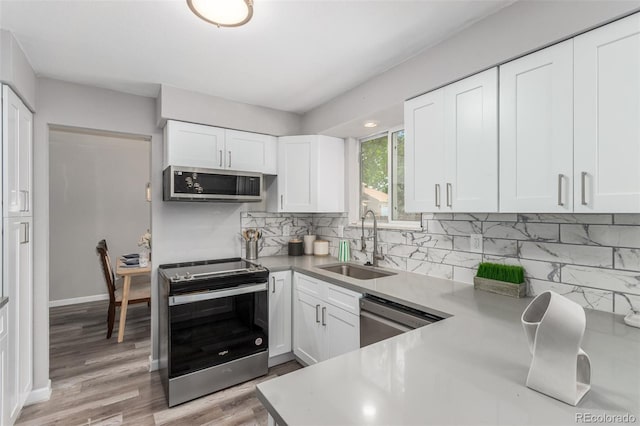 kitchen featuring light hardwood / wood-style floors, appliances with stainless steel finishes, white cabinets, and sink