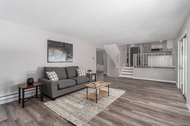 living room with a baseboard heating unit and hardwood / wood-style floors