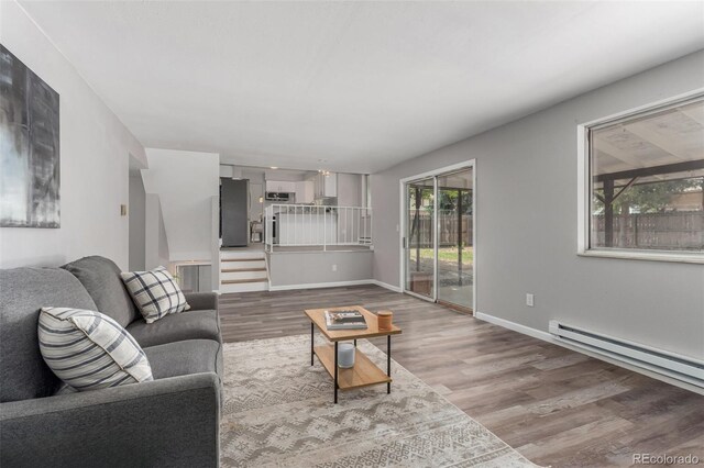 living room with baseboard heating and wood-type flooring