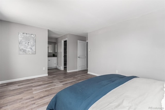 bedroom featuring hardwood / wood-style floors and ensuite bathroom