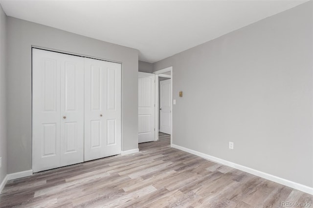 unfurnished bedroom with light hardwood / wood-style flooring and a closet