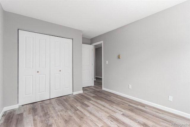 unfurnished bedroom with light hardwood / wood-style floors and a closet