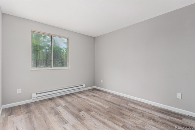 empty room with a baseboard heating unit and light hardwood / wood-style floors