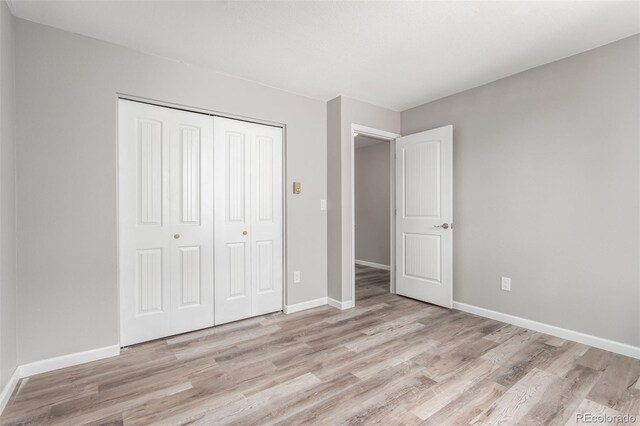 unfurnished bedroom featuring light hardwood / wood-style flooring and a closet