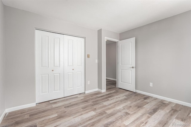 unfurnished bedroom featuring light hardwood / wood-style floors and a closet