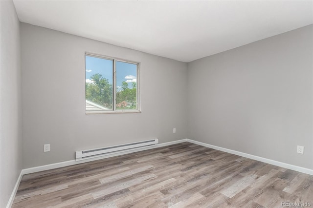 unfurnished room featuring a baseboard radiator and light wood-type flooring