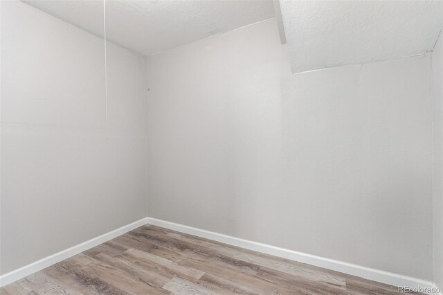 spare room featuring hardwood / wood-style floors and a textured ceiling