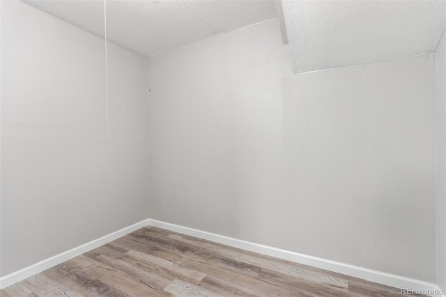 spare room featuring wood-type flooring and a textured ceiling