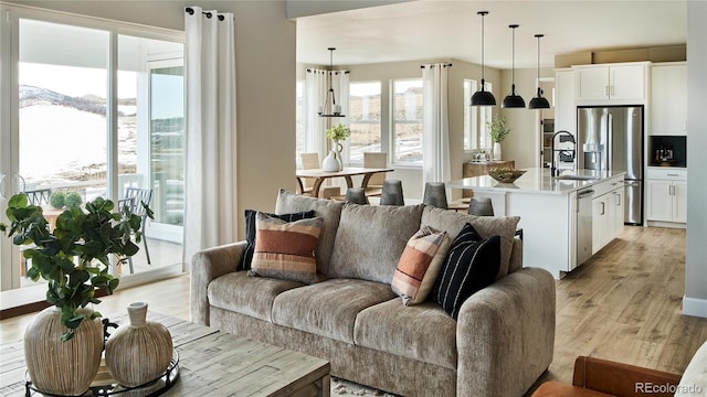 living room featuring light wood-type flooring and sink