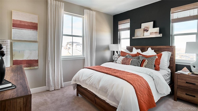 bedroom featuring light colored carpet and multiple windows