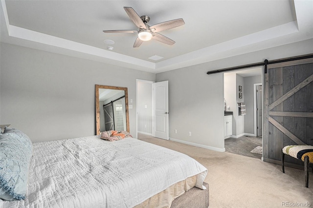 1473 Castle Creek Cir, Castle Rock, CO 80104 - bedroom featuring a tray ceiling, carpet, a barn door, and ensuite bath