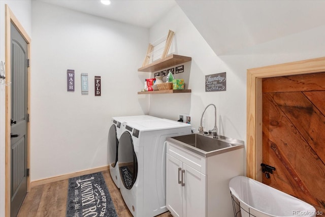 laundry area with dark hardwood / wood-style floors, cabinets, sink, and washing machine and clothes dryer