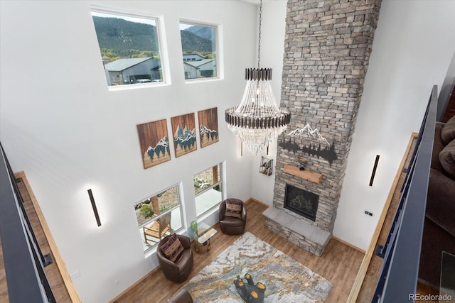 living room with a fireplace, wood-type flooring, and a chandelier