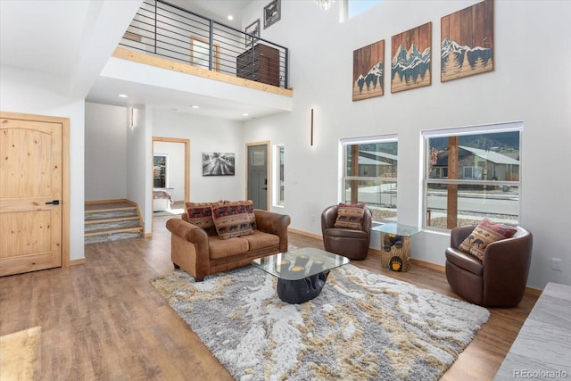 living room with wood-type flooring and a high ceiling