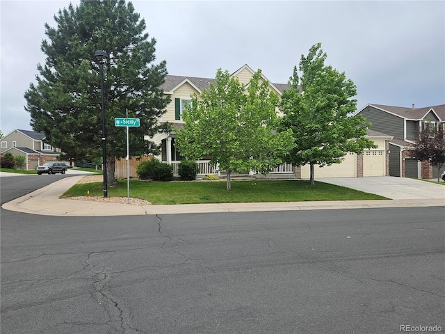 5571 S Sicily St, Aurora, CO 80015 - obstructed view of property featuring concrete driveway, a garage, and a front yard