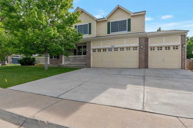 5571 S Sicily St, Aurora, CO 80015 - view of front of house with brick siding, driveway, a front lawn, and an attached garage
