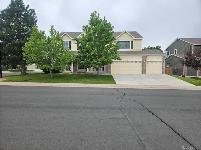 5571 S Sicily St, Aurora, CO 80015 - view of property hidden behind natural elements featuring driveway, brick siding, a front yard, and an attached garage