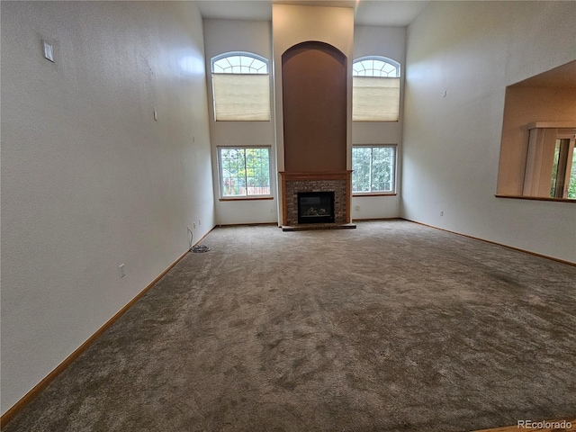 5571 S Sicily St, Aurora, CO 80015 - unfurnished living room with a high ceiling, carpet floors, and a glass covered fireplace