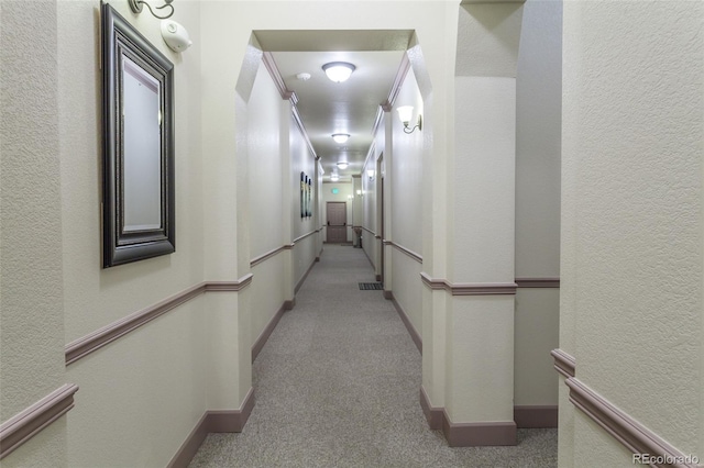 corridor with light colored carpet and crown molding