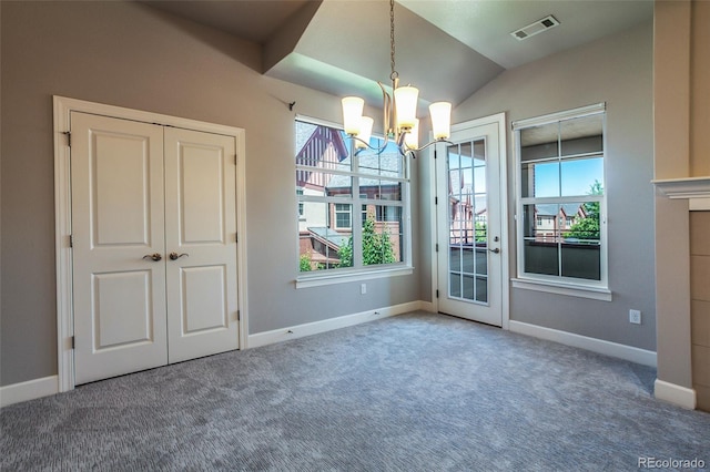 unfurnished dining area with carpet flooring, a notable chandelier, and lofted ceiling