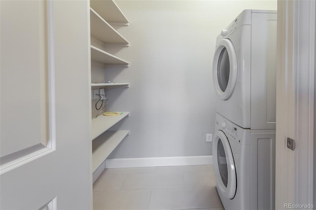 laundry room featuring stacked washer / drying machine and light tile patterned flooring