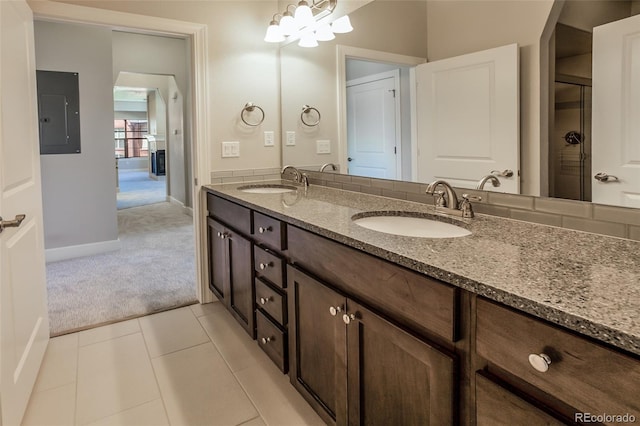 bathroom with electric panel, tile patterned flooring, vanity, and an inviting chandelier