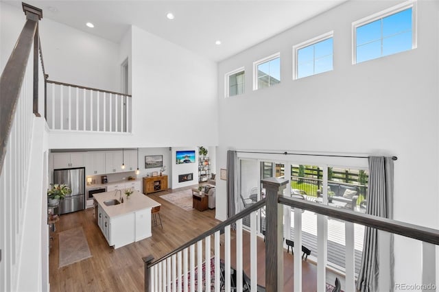 9016 Moondance Dr, Littleton, CO 80125 - staircase with a towering ceiling, wood finished floors, and recessed lighting