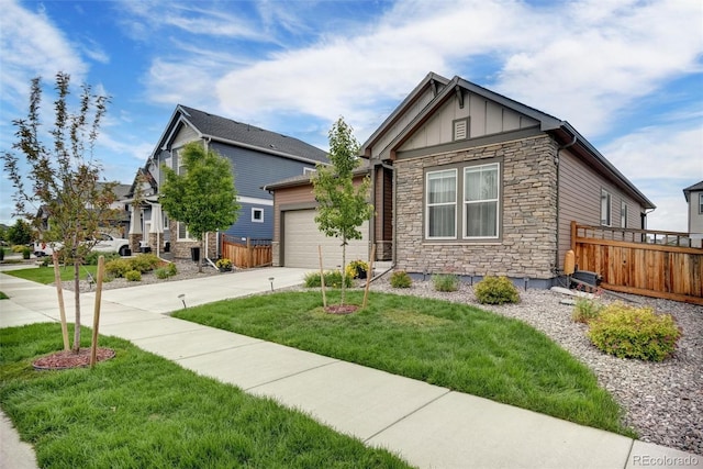 5771 Slate River Pl, Brighton, CO 80601 - view of front of home with stone siding, board and batten siding, driveway, and an attached garage