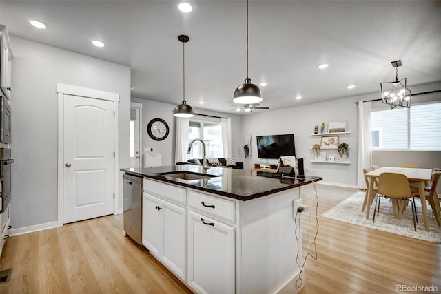 5771 Slate River Pl, Brighton, CO 80601 - kitchen with a sink, appliances with stainless steel finishes, light wood-type flooring, a kitchen island with sink, and white cabinetry
