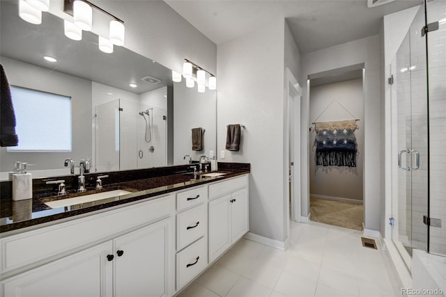 5771 Slate River Pl, Brighton, CO 80601 - bathroom with a stall shower, double vanity, a spacious closet, tile patterned floors, and baseboards