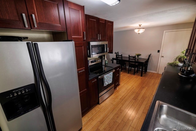 18908 E Napa Dr, Aurora, CO 80013 - kitchen featuring appliances with stainless steel finishes, reddish brown cabinets, light wood-style flooring, and baseboards