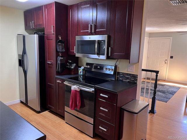 18908 E Napa Dr, Aurora, CO 80013 - kitchen with stainless steel appliances, light wood finished floors, dark countertops, and dark brown cabinets