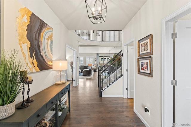 10091 Hannaway Dr, Colorado Springs, CO 80924 - corridor featuring a chandelier, dark wood-style floors, stairway, and baseboards