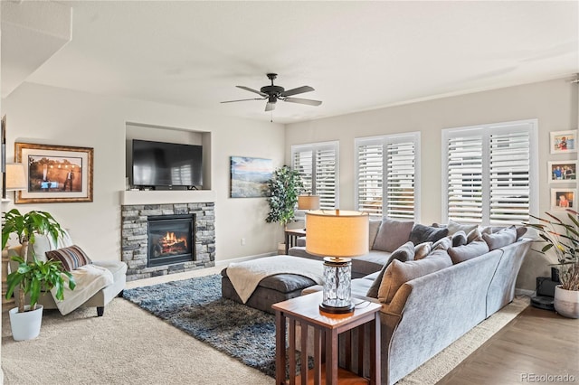 10091 Hannaway Dr, Colorado Springs, CO 80924 - living room featuring ceiling fan, a stone fireplace, and wood finished floors