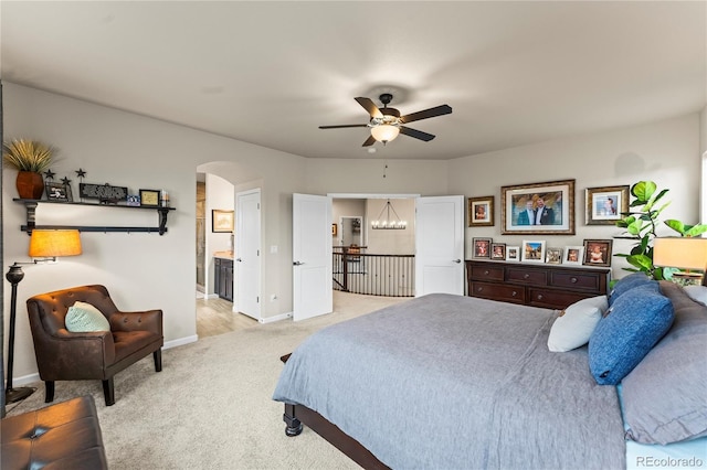 10091 Hannaway Dr, Colorado Springs, CO 80924 - bedroom with arched walkways, light carpet, baseboards, ensuite bath, and ceiling fan