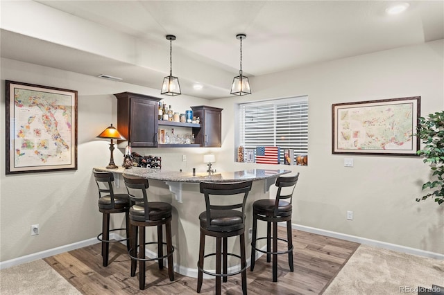 10091 Hannaway Dr, Colorado Springs, CO 80924 - indoor wet bar with light wood finished floors, baseboards, and hanging light fixtures