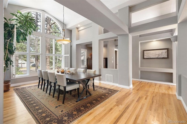 dining area with wood finished floors, visible vents, and baseboards