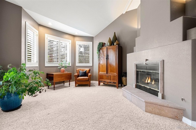 living area with baseboards, recessed lighting, vaulted ceiling, a glass covered fireplace, and carpet flooring