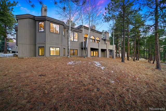 rear view of property featuring a chimney