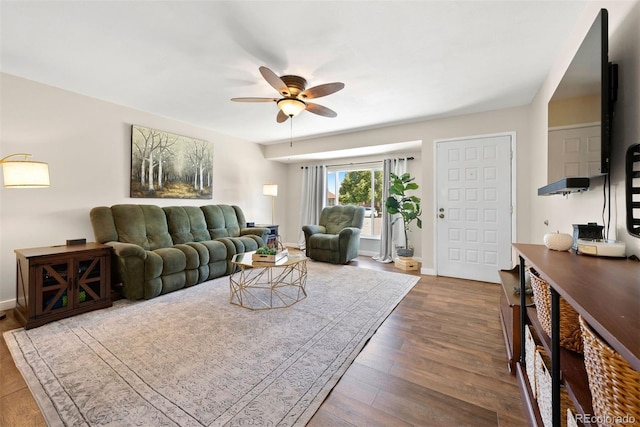 living area with ceiling fan, baseboards, and dark wood-style flooring