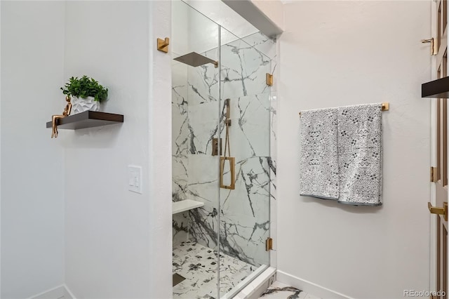 bathroom featuring marble finish floor, baseboards, and a marble finish shower