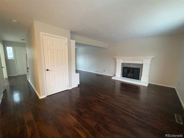 unfurnished living room with a high end fireplace and dark hardwood / wood-style flooring