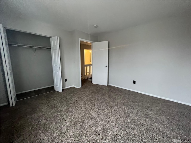 unfurnished bedroom with a closet and dark carpet