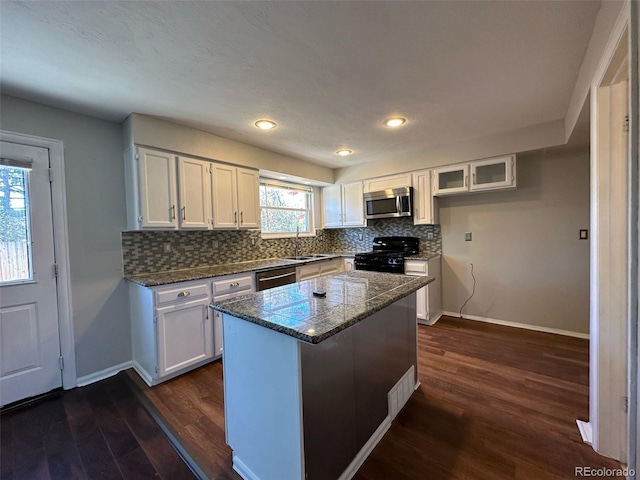 kitchen featuring white cabinets, black range, a healthy amount of sunlight, and dark hardwood / wood-style flooring