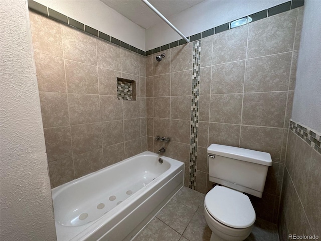 bathroom featuring tiled shower / bath combo, tile walls, tile flooring, and toilet