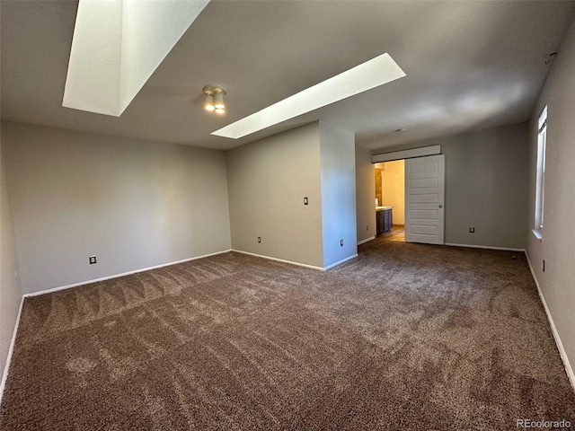 carpeted spare room featuring a skylight