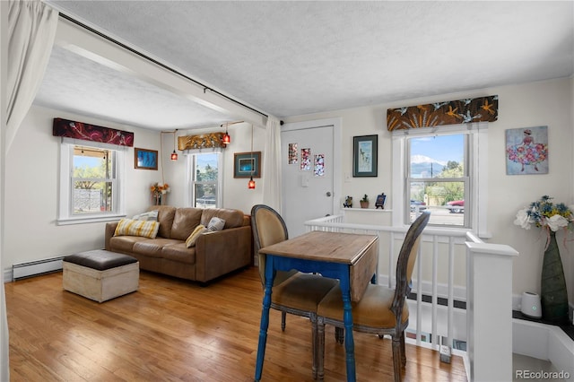 831 Manitou Blvd, Colorado Springs, CO 80904 - dining area with a healthy amount of sunlight, a textured ceiling, a baseboard radiator, and wood finished floors
