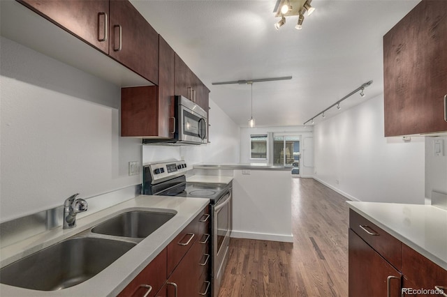 1245 Columbine St Unit 306, Denver, CO 80206 - kitchen featuring appliances with stainless steel finishes, track lighting, light countertops, and dark wood-style floors